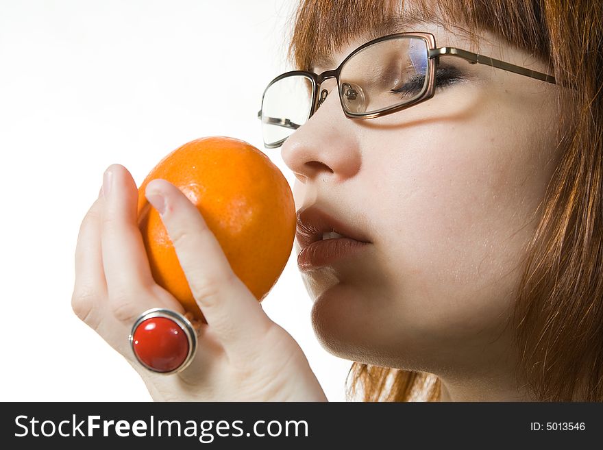 Young woman in glasses smelling mandarin and enjoying it. Young woman in glasses smelling mandarin and enjoying it.