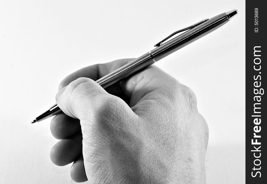 Photo of a hand holding a pen just about to write a letter. Photo of a hand holding a pen just about to write a letter