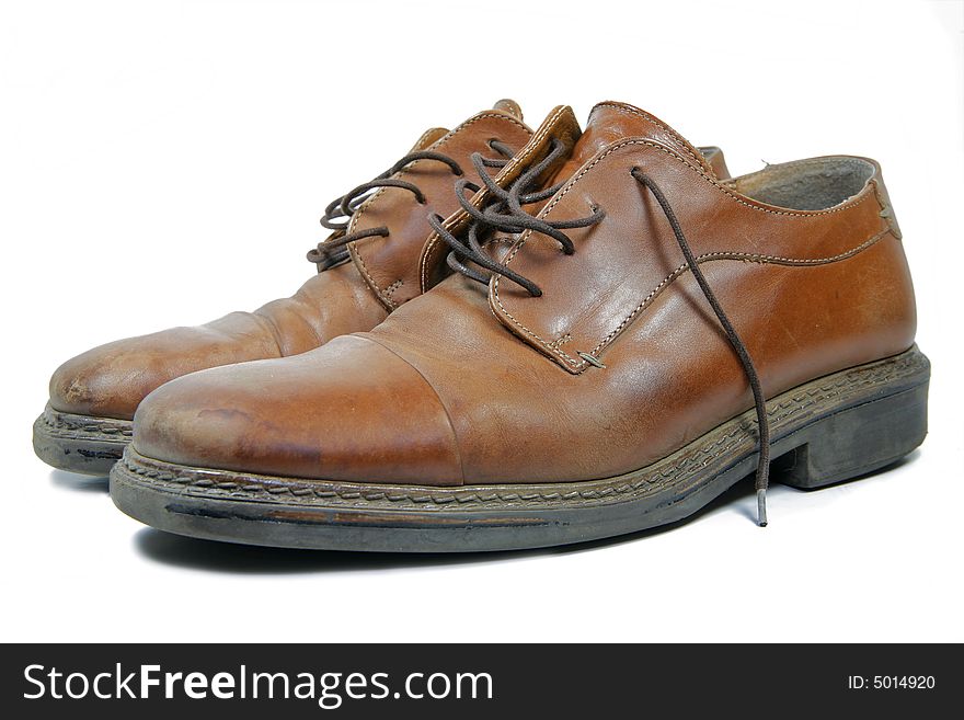 A pair of old brown leather shoes isolated on white. A pair of old brown leather shoes isolated on white