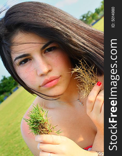 Woman holding a live and dead patch of grass. Woman holding a live and dead patch of grass.