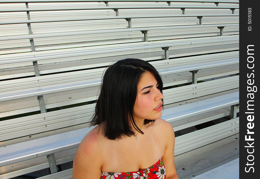 Woman sitting and watching a football game alone. Woman sitting and watching a football game alone.