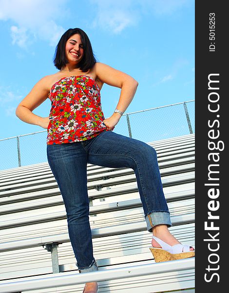 Woman standing on bleachers and smiling.