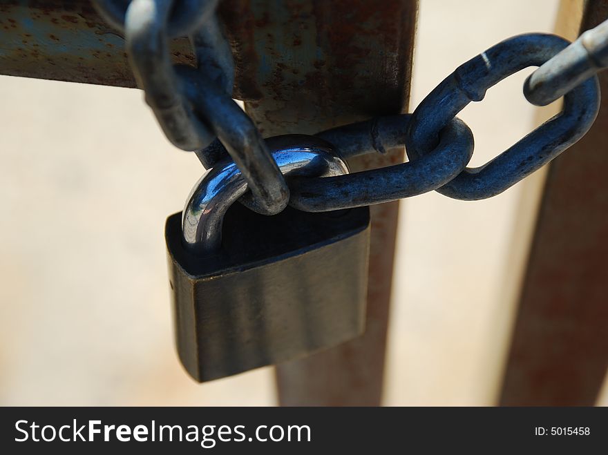 A padlock and chain securing a gate. A padlock and chain securing a gate