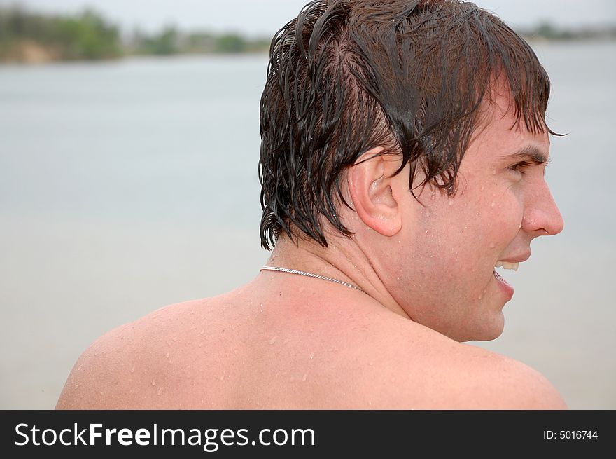 Young smiling swimmer with wet hair after swimming