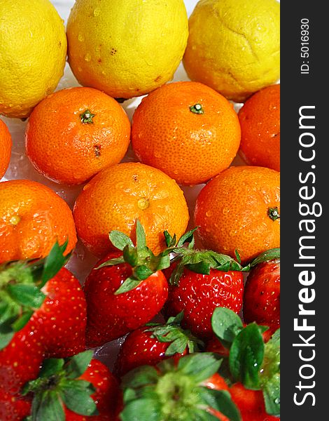 An image of fresh strawberries, lemons, and tangerines. An image of fresh strawberries, lemons, and tangerines