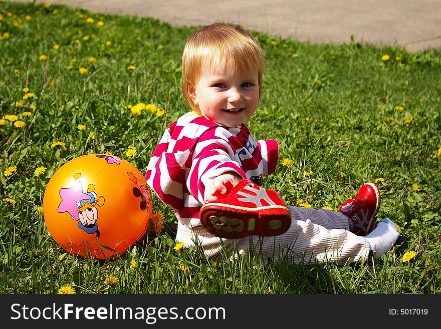 The little girl with ball on a grass. The little girl with ball on a grass