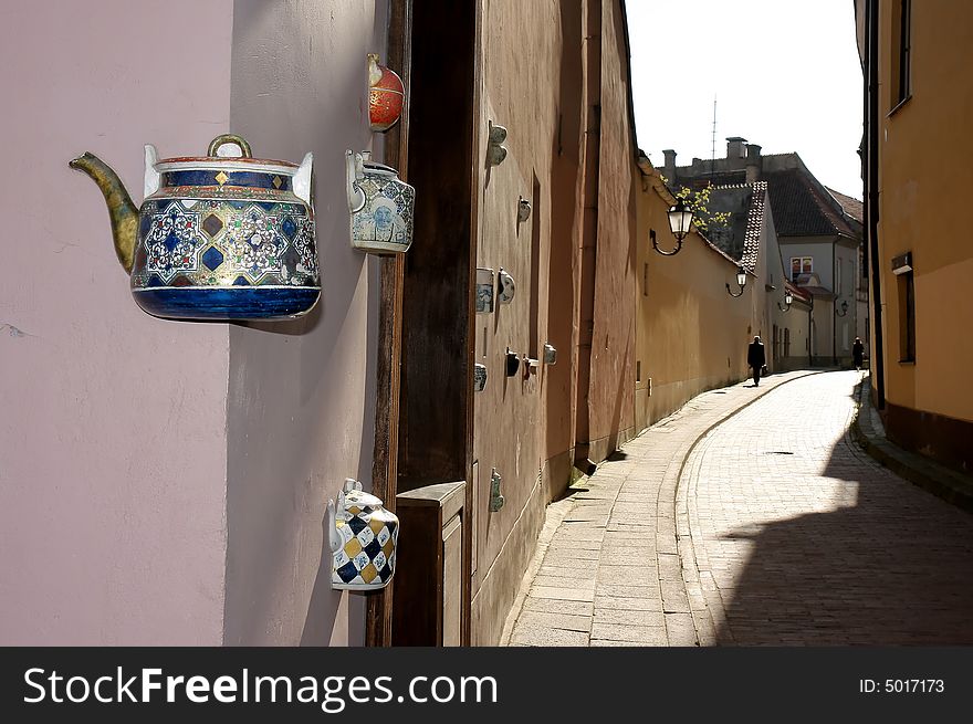 There is composition of colorful teapots in wall. There is composition of colorful teapots in wall