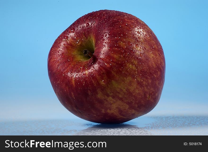 red apple on wet blue background nuanced. red apple on wet blue background nuanced