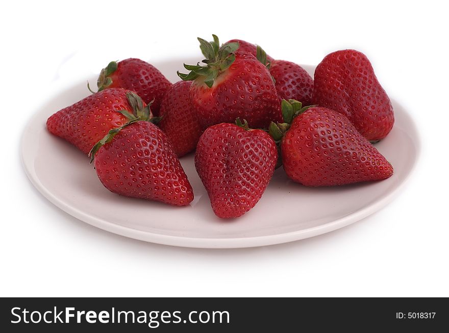Red, juicy strawberries on white plate on white background