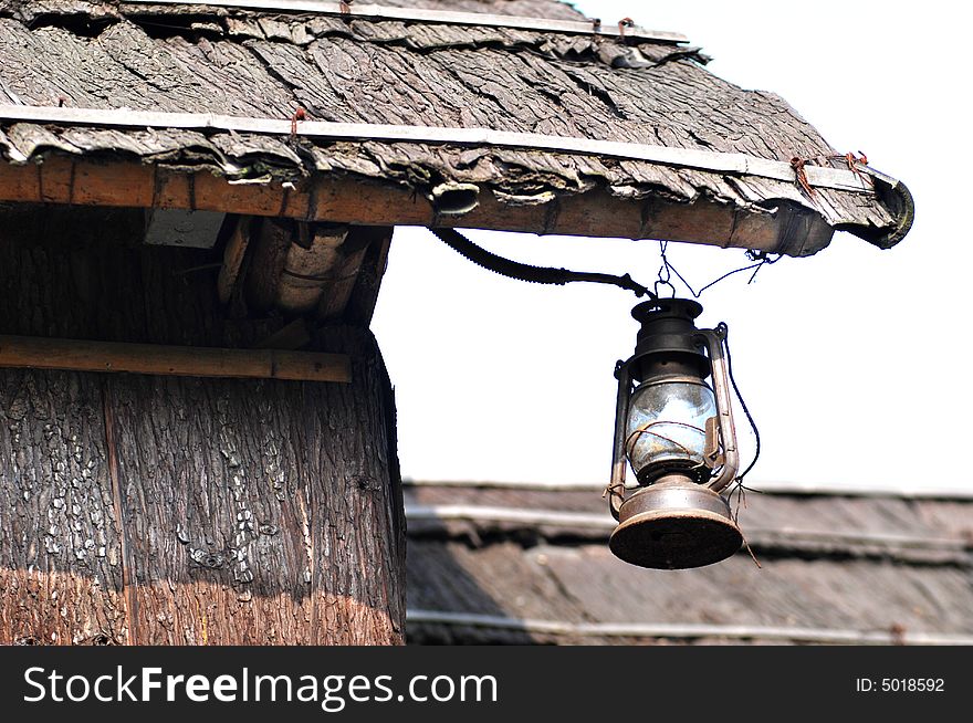 A hurricane lamp hung under the thatched eave. A hurricane lamp hung under the thatched eave.