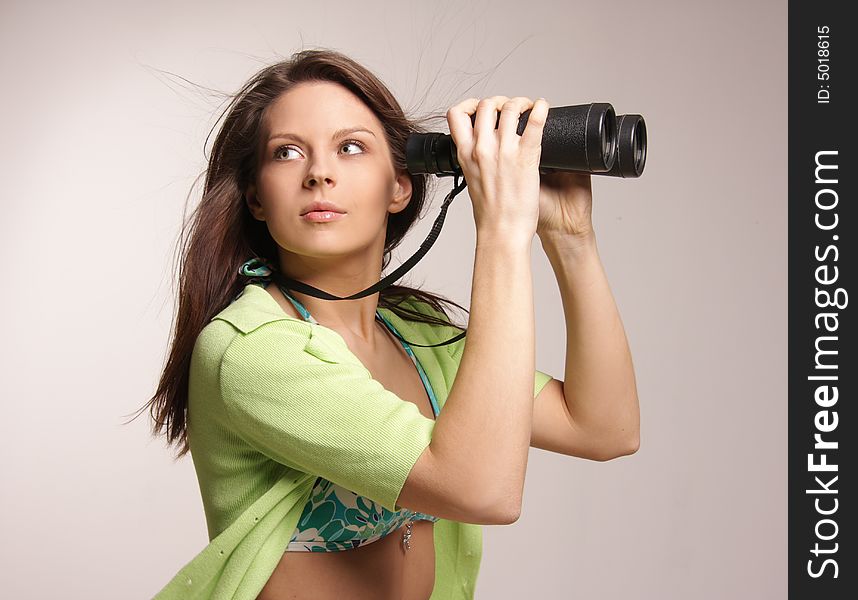 Beautiful, attractive woman looking through binoculars.