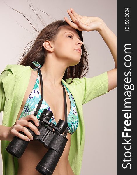 Beautiful, attractive woman looking through binoculars.