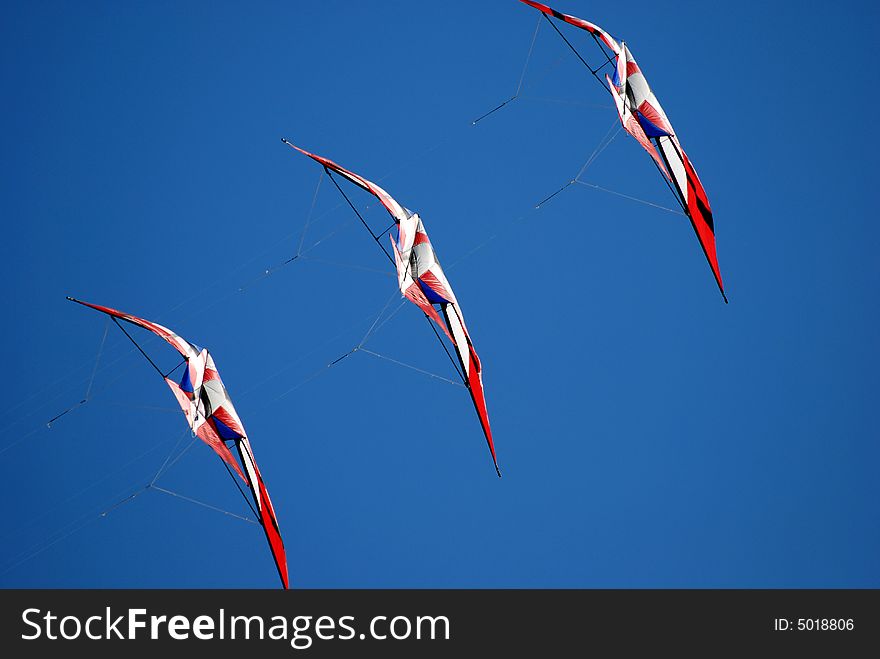 Acrobatic kites flying in the blue sky