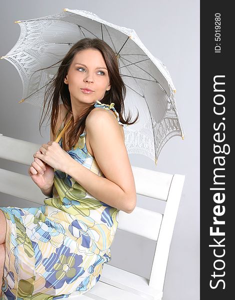 Young brunette girl with umbrella in white.
