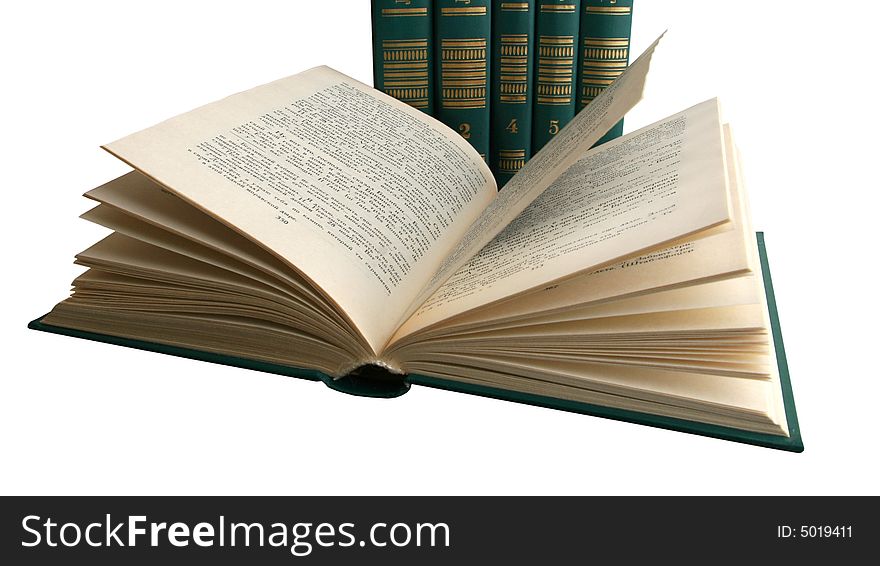 The open book, lays before other books, isolated on a white background