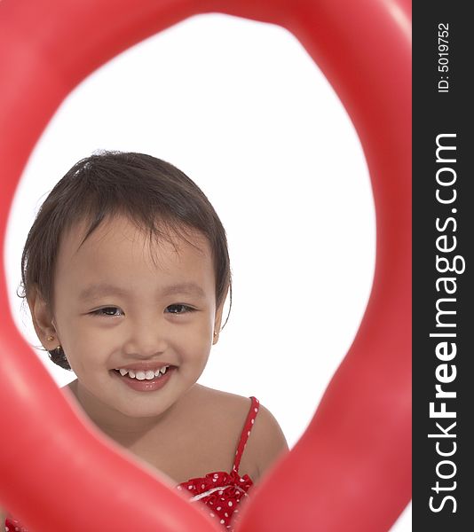 Smiling young girl on a red big balloon