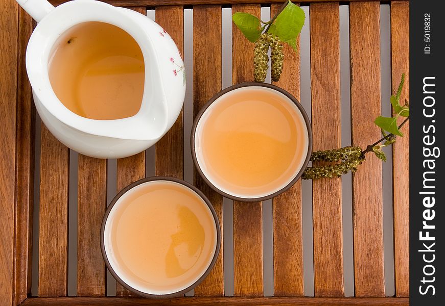 Green tea in cups serving on wooden tray.