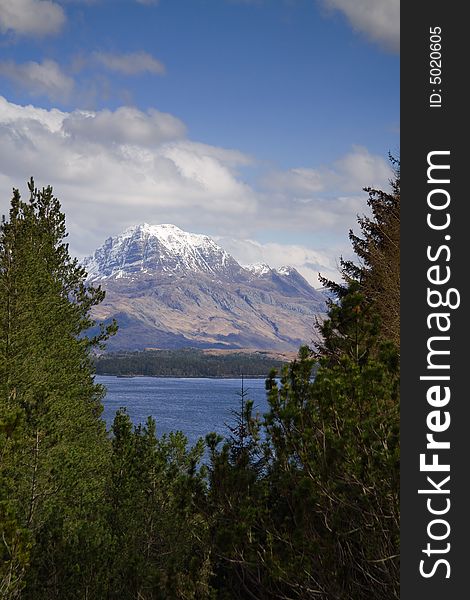 Scottish mountain Slioch through trees over Loch Maree. Scottish mountain Slioch through trees over Loch Maree