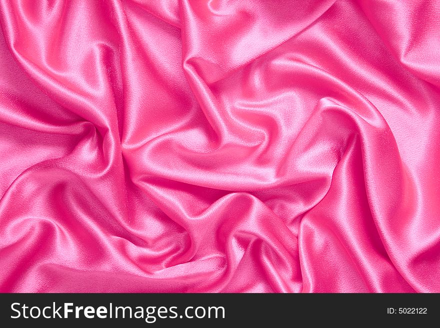 Background. Pink satin fabric with folds. Background. Pink satin fabric with folds