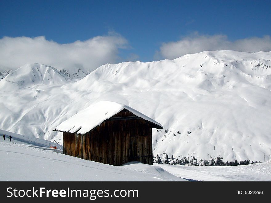 Beautiful snowy mountains and alpine cottage.