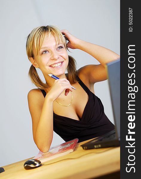 A young blonde girl working with a notebook in an office