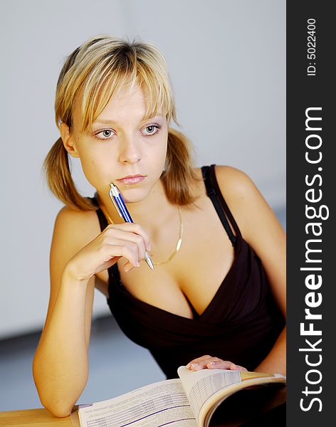 A young blonde girl working with a notebook in an office