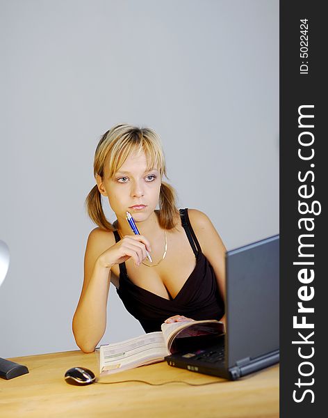 A young blonde girl working with a notebook in an office
