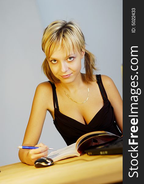 A young blonde girl working with a notebook in an office