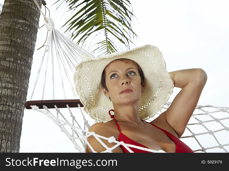 View of nice woman lounging in hammock in tropical environment