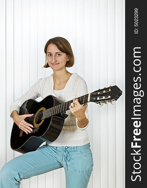 Pretty young woman playing the guitar. Pretty young woman playing the guitar.
