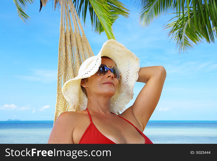 View of nice woman lounging in hammock in tropical environment. View of nice woman lounging in hammock in tropical environment