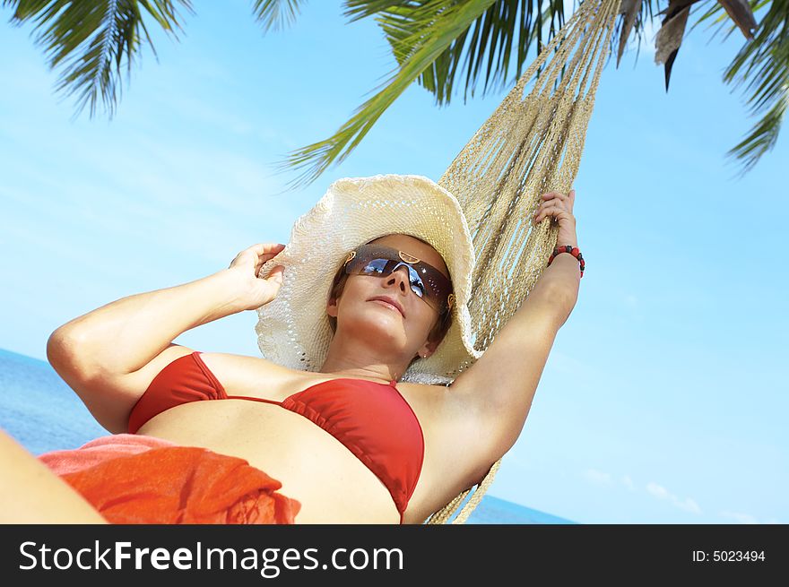 View of nice woman lounging in hammock in tropical environment. View of nice woman lounging in hammock in tropical environment