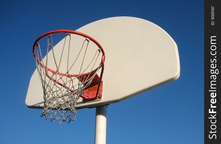 Basketball net with backboard against a blue sky. Basketball net with backboard against a blue sky