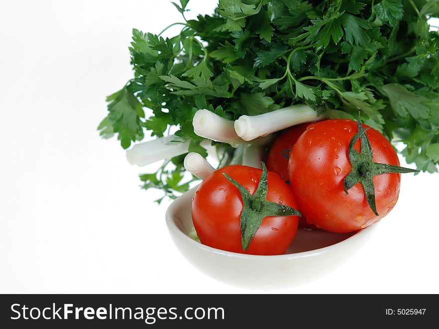 Fresh green onions, parsley and tomatoes are placed in ceramic bowl on white background. Fresh green onions, parsley and tomatoes are placed in ceramic bowl on white background