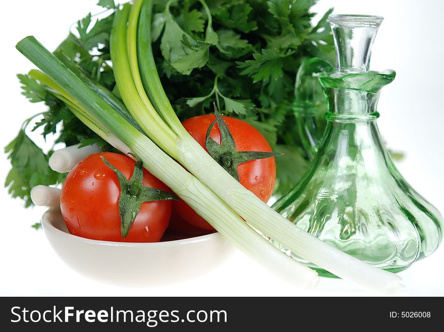 Close up to Fresh onions, tomatoes and parsley with salad dressing jar over white. Close up to Fresh onions, tomatoes and parsley with salad dressing jar over white