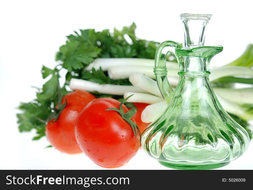 Fresh tomatoes, onions and parsley with salad dressing jar over white. Fresh tomatoes, onions and parsley with salad dressing jar over white