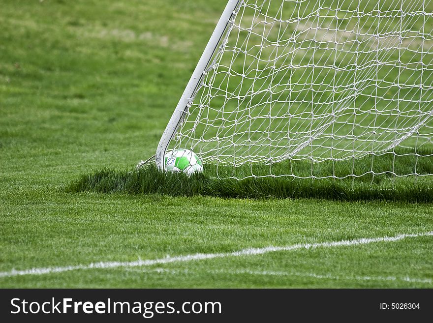 Soccer ball sitting in the back corner of the goal. Soccer ball sitting in the back corner of the goal.