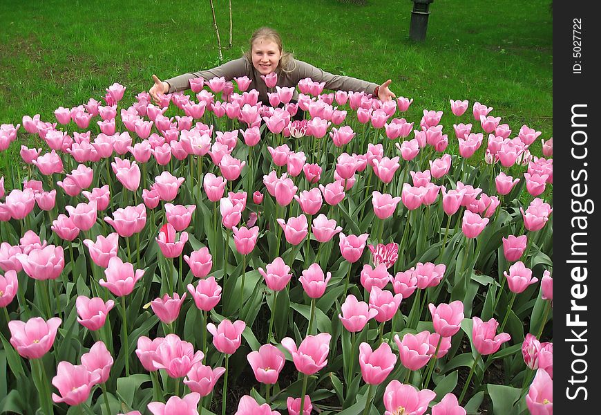 Beautiful girl sitting in the meadow among white tulips. Beautiful girl sitting in the meadow among white tulips