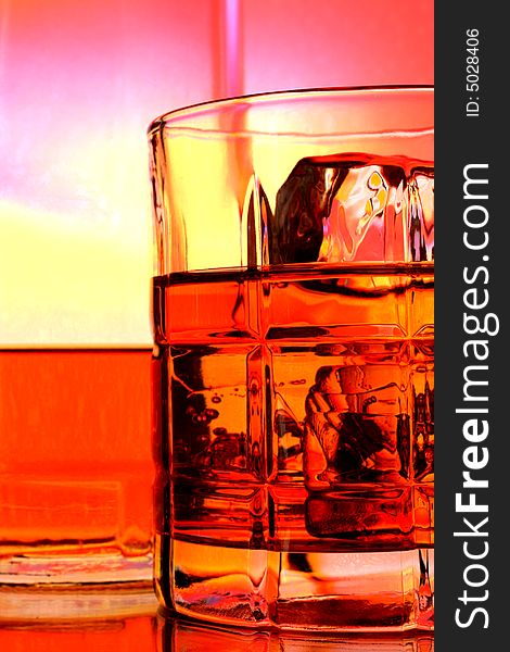 Bottle and glasses of whiskey against multi colored abstract background. Bottle and glasses of whiskey against multi colored abstract background.