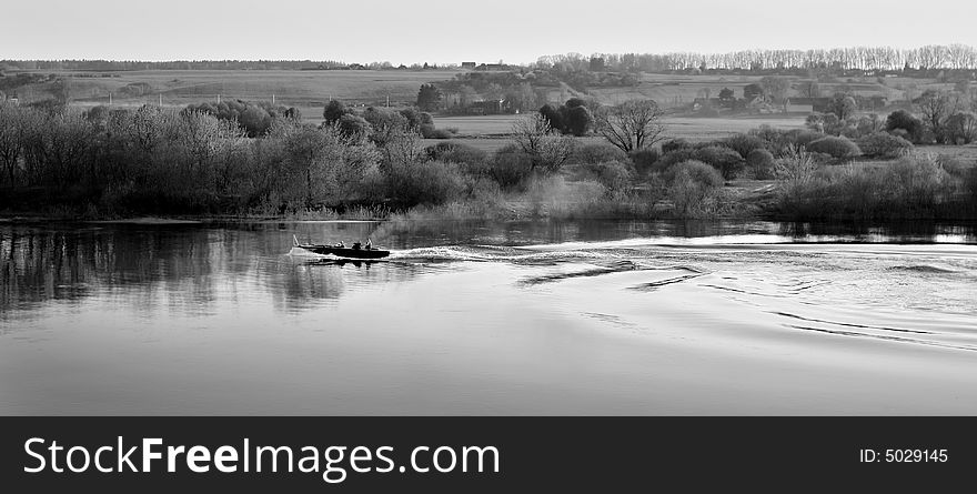 Image illustrating active relaxation: fishing and swimming with the motor boat in the countryside