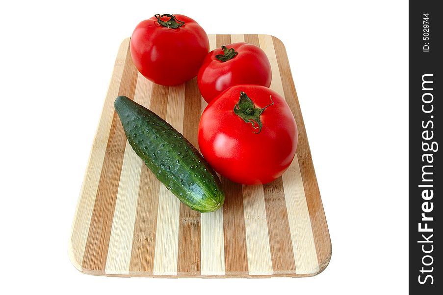 Vegetables (tomatoes and cucumber) on bamboo cutting board. Vegetables (tomatoes and cucumber) on bamboo cutting board.