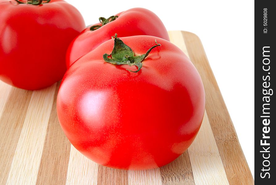 Vegetables (few tomatoes) on bamboo cutting board. Vegetables (few tomatoes) on bamboo cutting board.