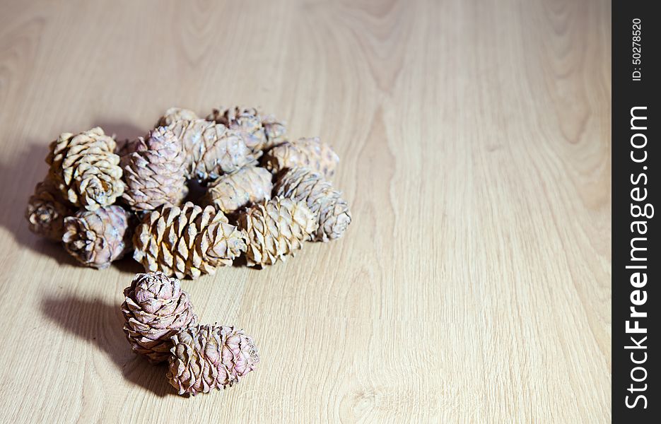 Some cedar cones lying on wooden floor