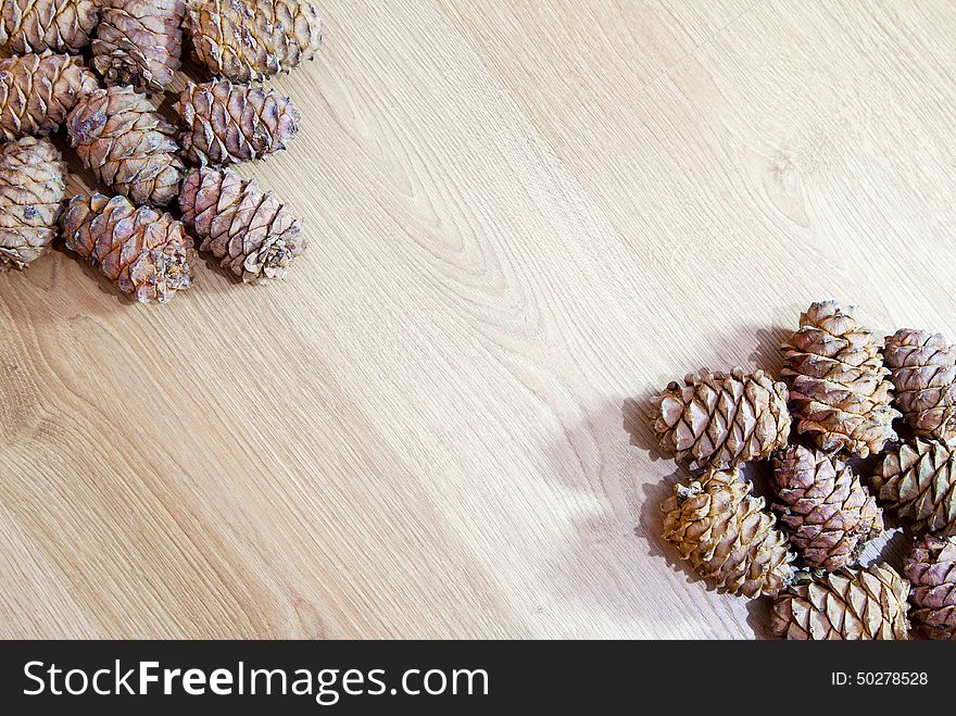 Frame with cedar cones on wooden floor