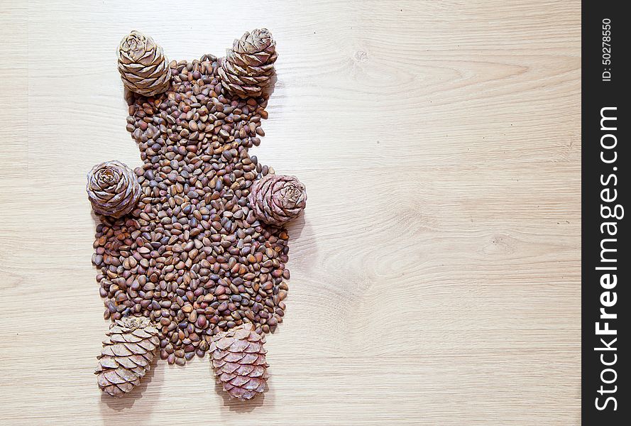 Bear from cedar cones on wooden floor