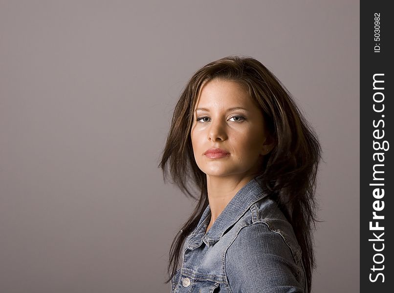 A young brunette in a denim jacket giving a sultry and sexy look. A young brunette in a denim jacket giving a sultry and sexy look