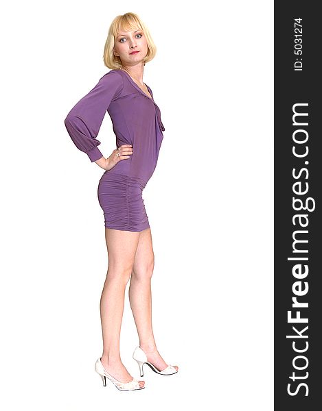 An friendly blond girl in an short tight purple dress standing in an studio 
for white background. An friendly blond girl in an short tight purple dress standing in an studio 
for white background.