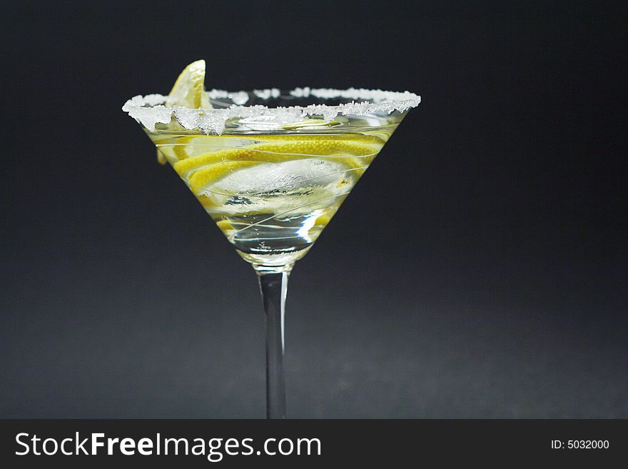 Martini with sugar crust, lemon and peels on white