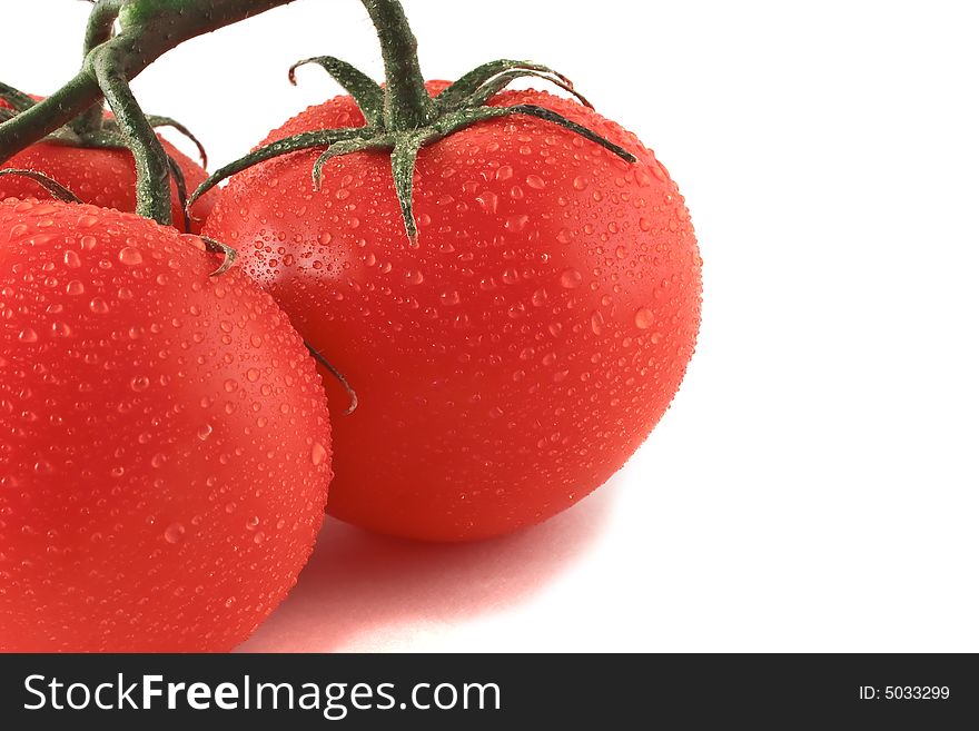 A show of three fresh tomatoes with condisation on them.