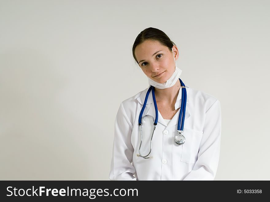 Young female doctor in a white coat sporting a stethoscope. Isolated.